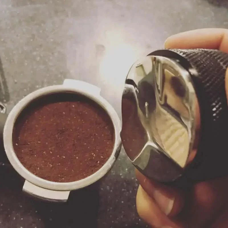 Coffee grounds and tamper.