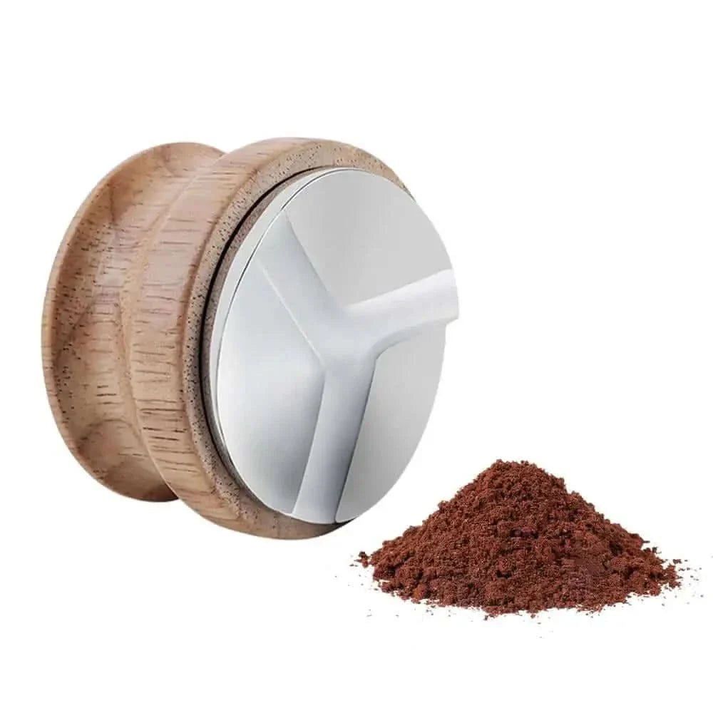 Coffee tamper with wooden handle and pile of ground coffee.