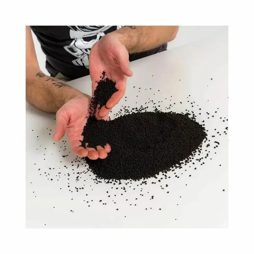 Pile of black granules held in hands.