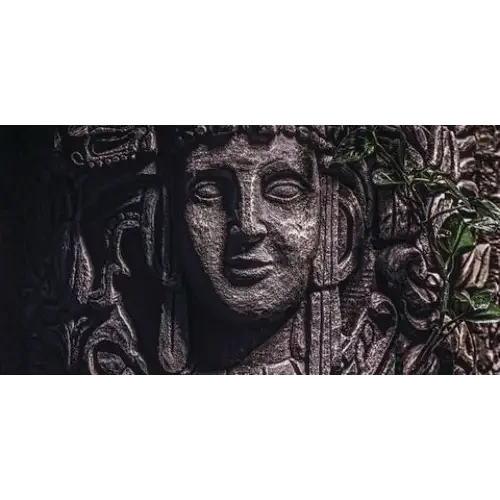 Stone carving of a serene face.