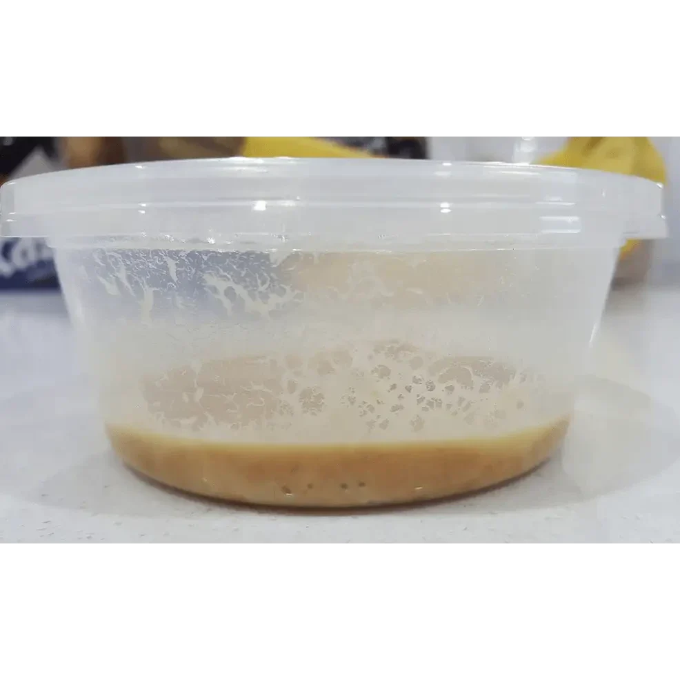 Tan liquid in a clear plastic container.