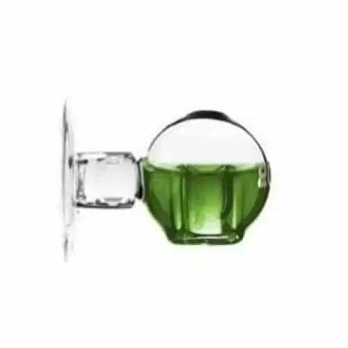 Glass wall-mounted soap dispenser with green liquid.
