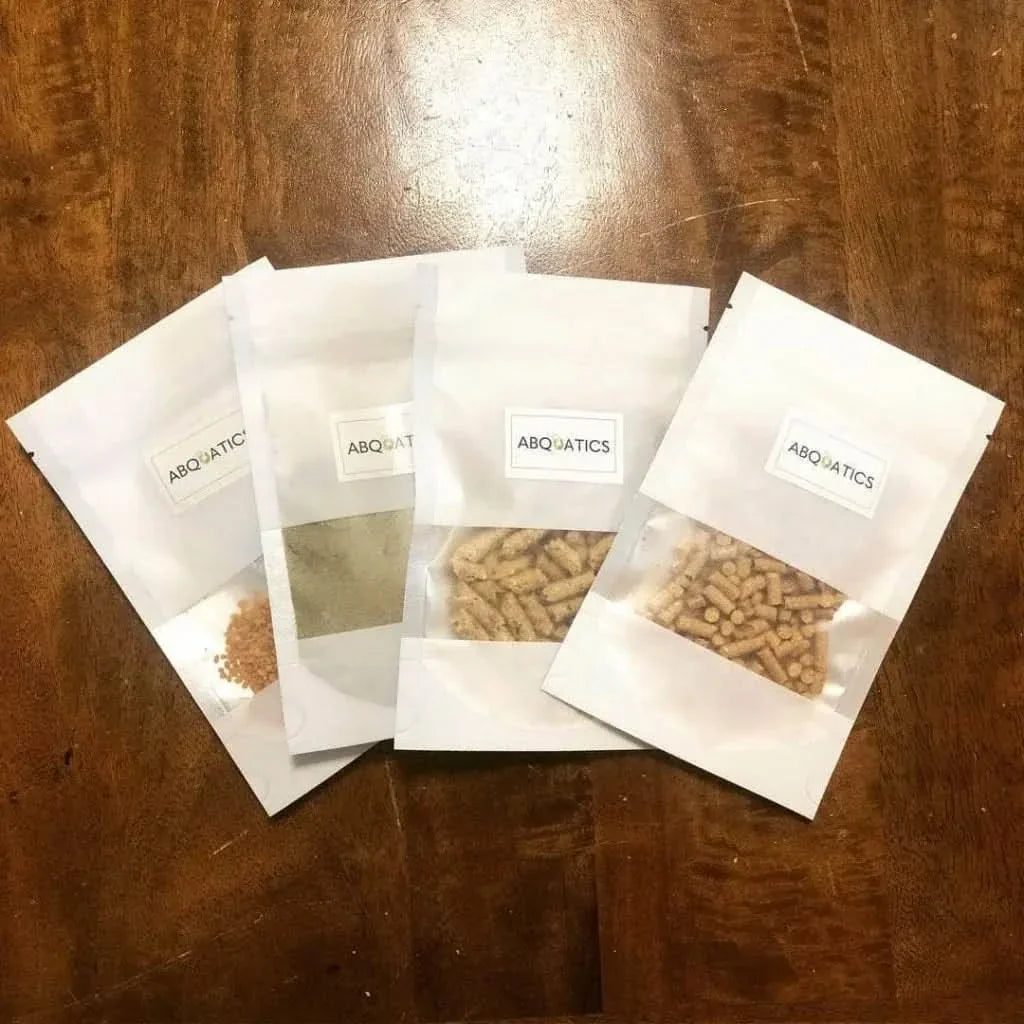 Four white packets of fish food.