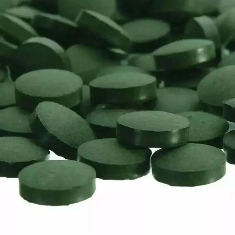 Pile of green spirulina tablets.