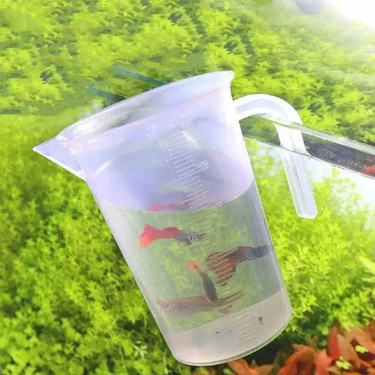 Clear plastic measuring cup with guppies.