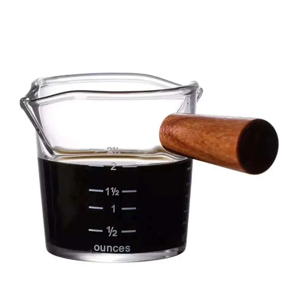 Glass measuring cup with wooden handle.