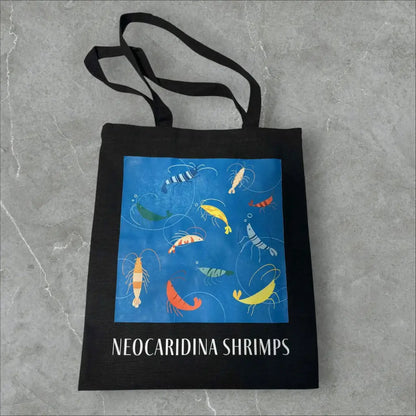Black tote bag with colorful shrimp illustration.