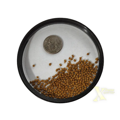 Round container with fish food and a quarter.