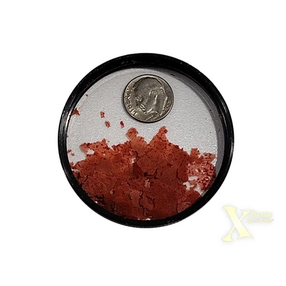 Round container with reddish contents and a dime.