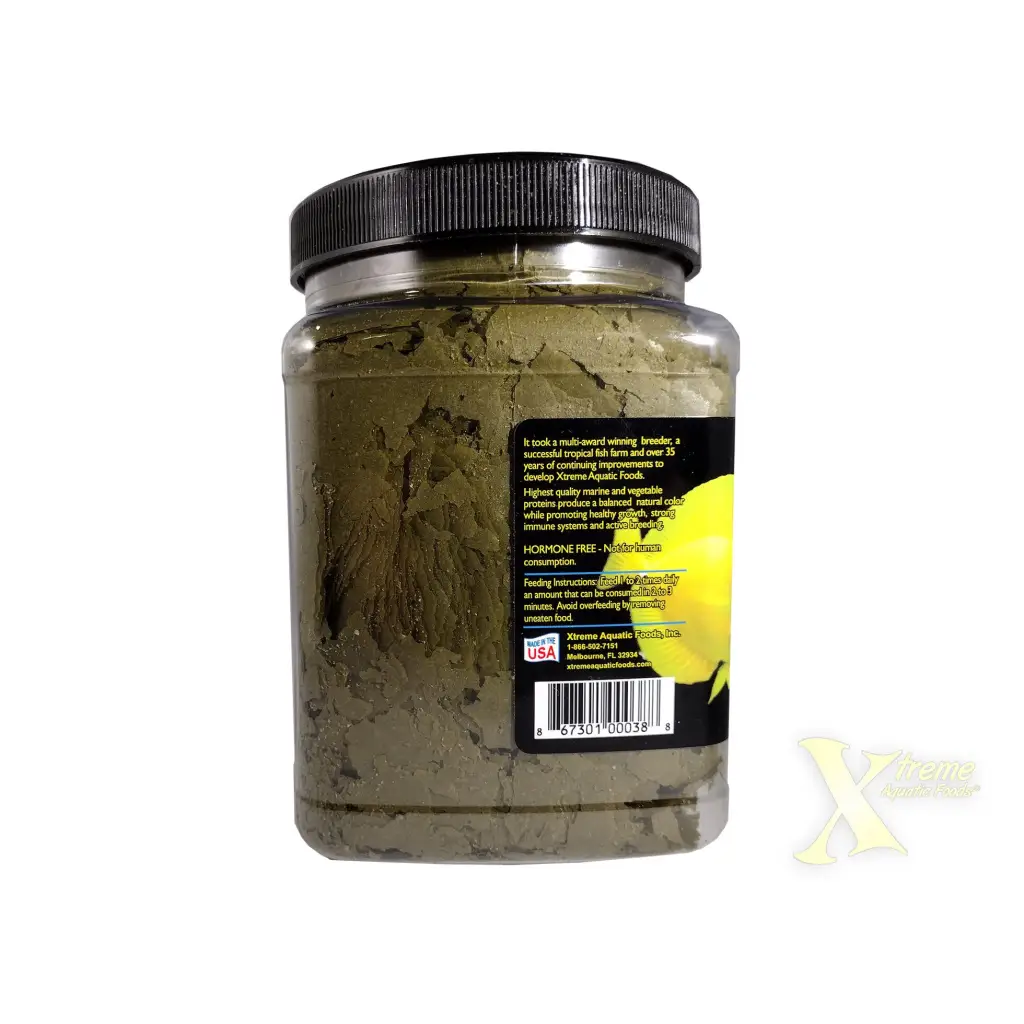 Container of green fish food flakes.