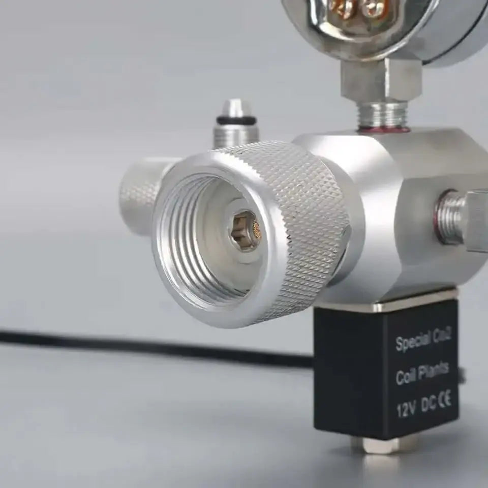 A silver-colored metal regulator with a hexagonal opening and a black solenoid valve attached.